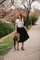 a lady in a white nit top and a black skirt